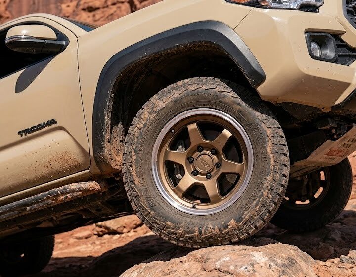 An off-road Toyota Tacoma navigating rocks, proving the durability of the aluminum New Toyota Hub Rings under extreme stress.