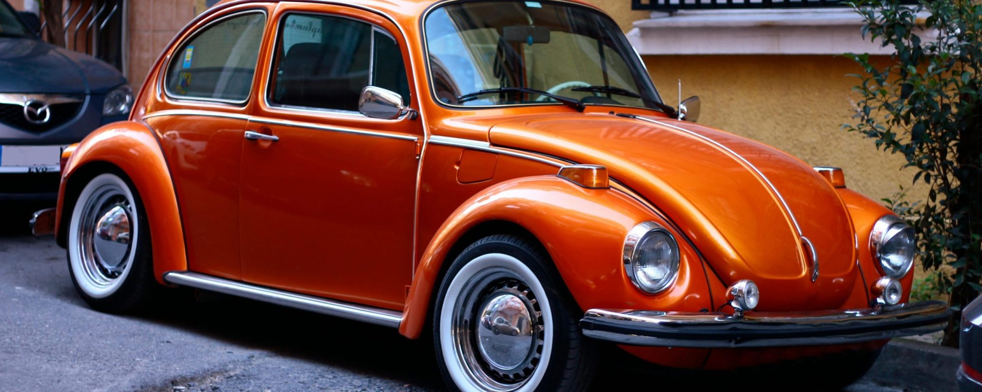 A classic orange Volkswagen Beetle parked on a street in Istanbul.