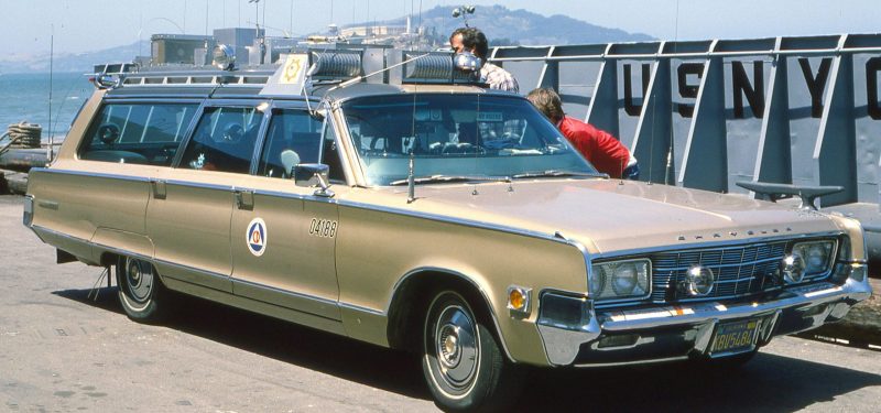 Classic Chrysler Town & Country at a harbor with retro style and picturesque backdrop.