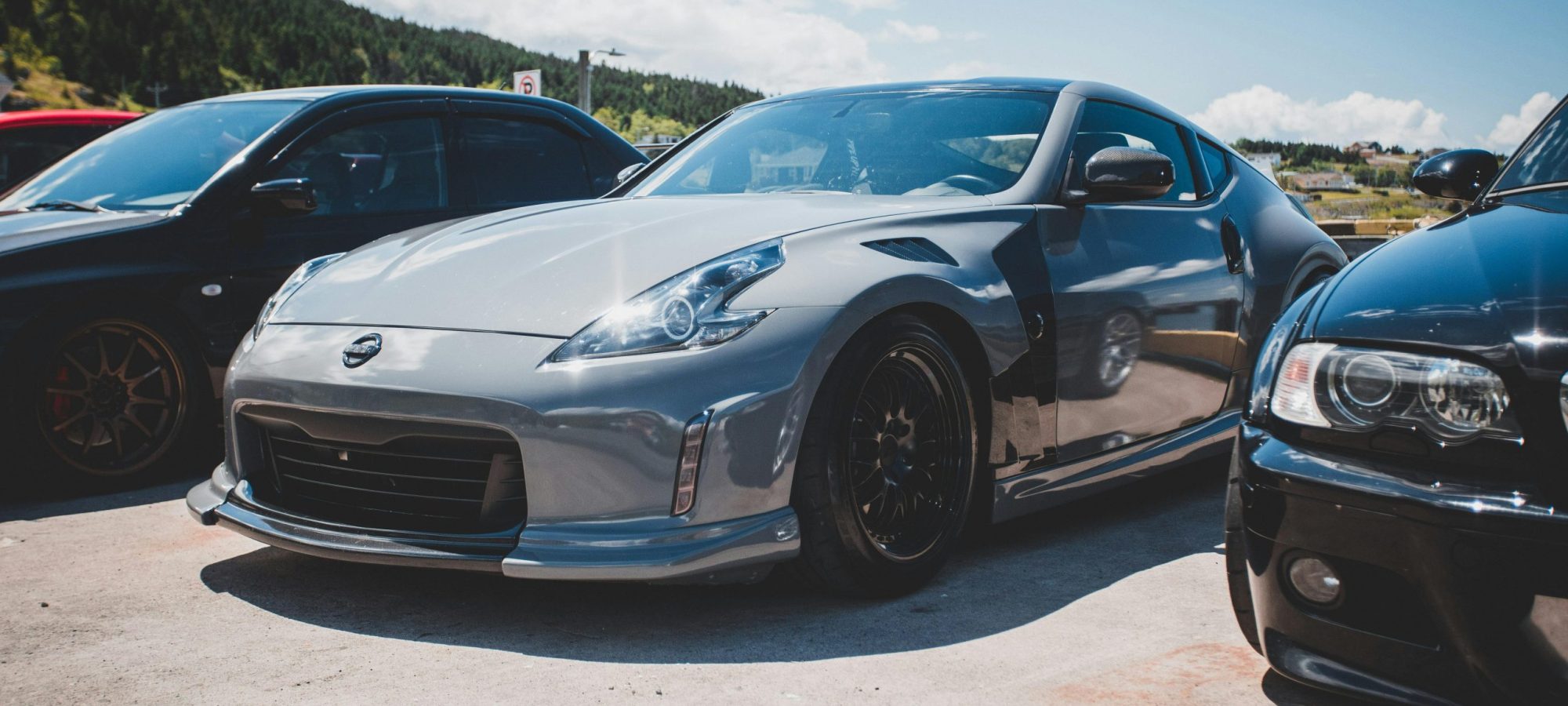 Silver Nissan Z-Car parked in a sunny outdoor lot, showcasing sleek design. by Erik Mclean via pexels