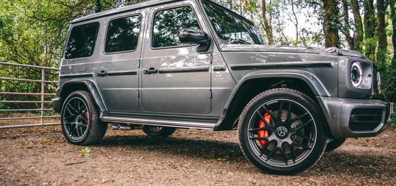 A luxurious Mercedes-Benz SUV parked in a scenic wooded area G-Wagon. by Lloyd Freeman