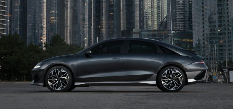Electric car parked against the backdrop of towering skyscrapers in Busan, South Korea. Hyundai Motor Group.