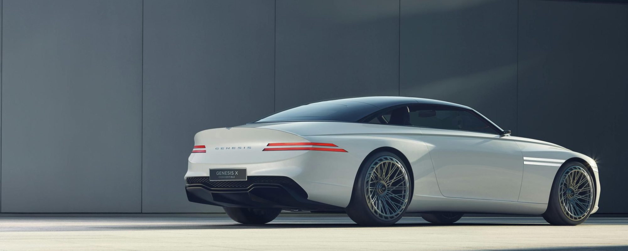 Sleek white Genesis car in a minimalist outdoor environment, showcasing modern automotive design.