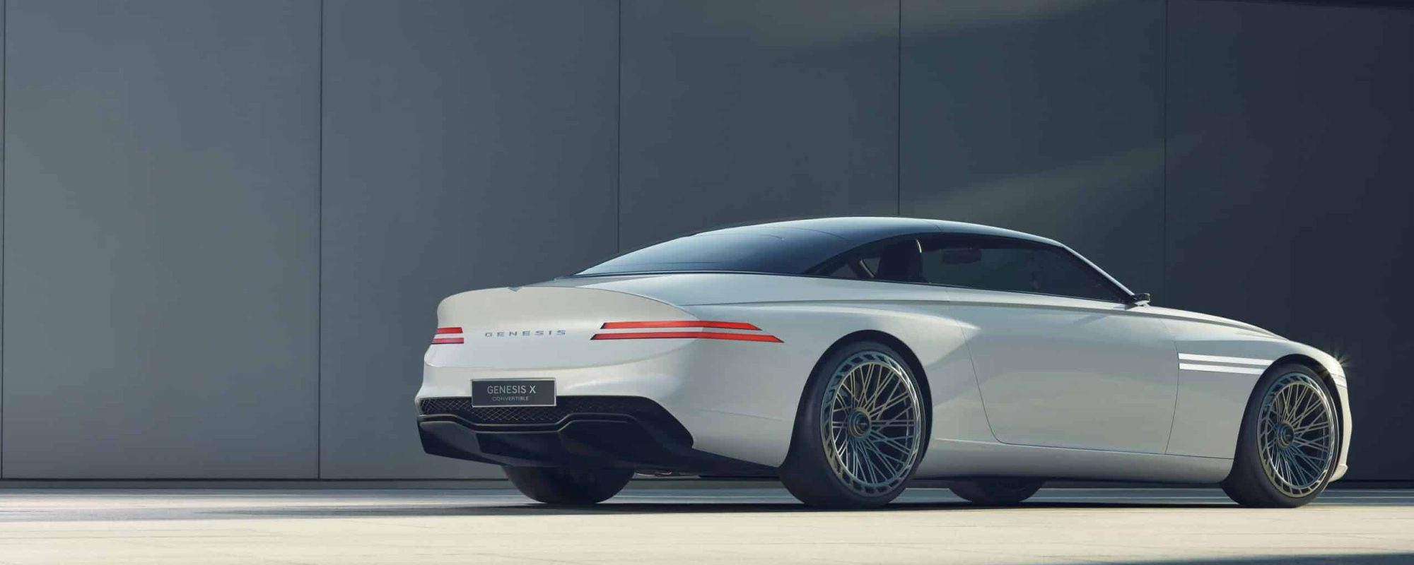 Sleek white Genesis car in a minimalist outdoor environment, showcasing modern automotive design.