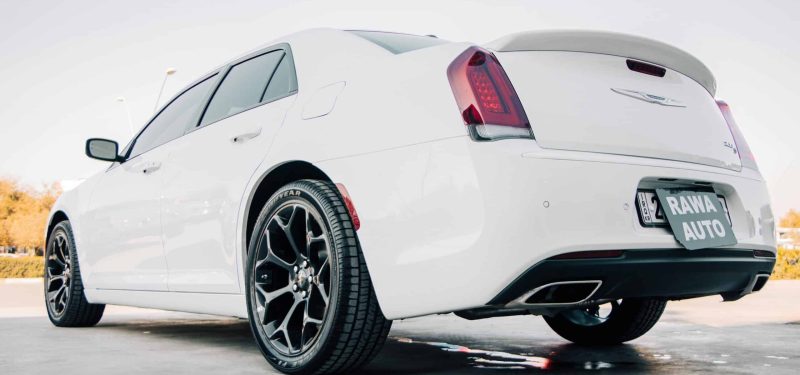 A rear view of a sleek white Chrysler 300 parked in sunny Erbil, Iraq.