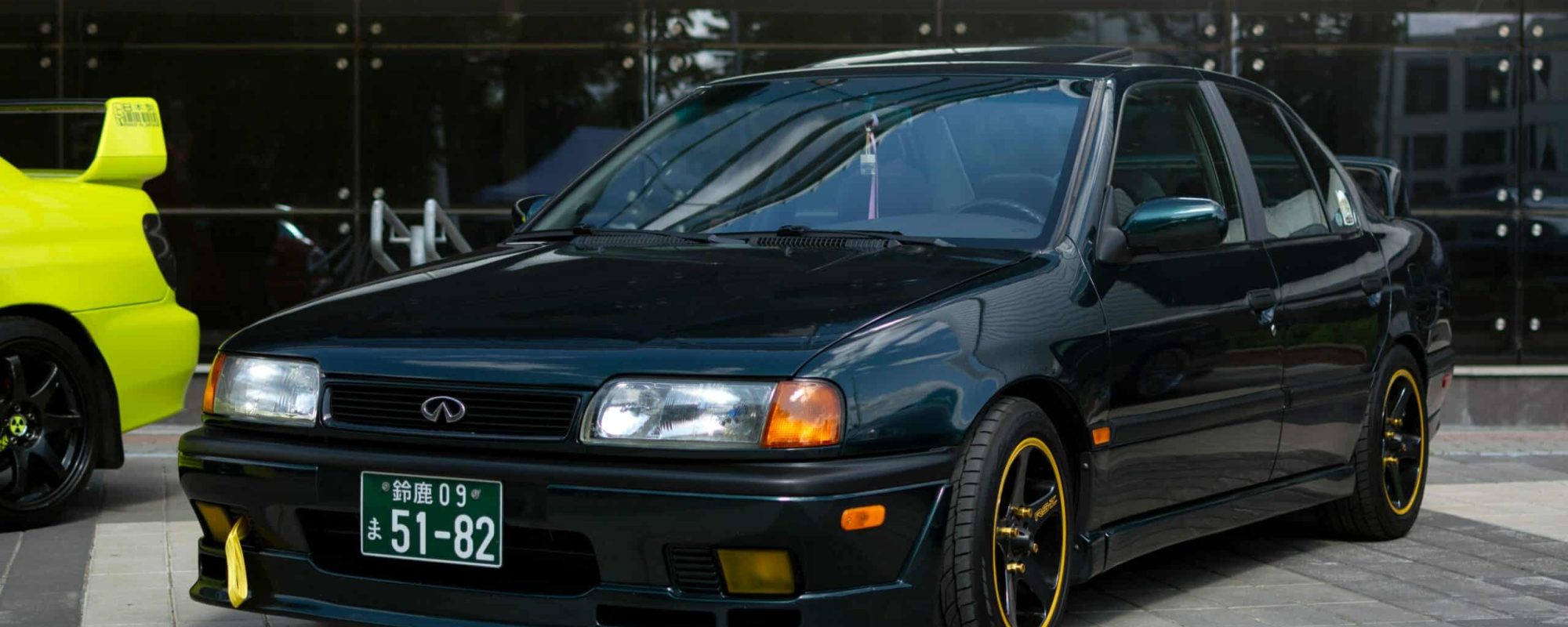 A black Infiniti car parked in an urban setting in Minsk, Belarus, showcasing its sleek design.