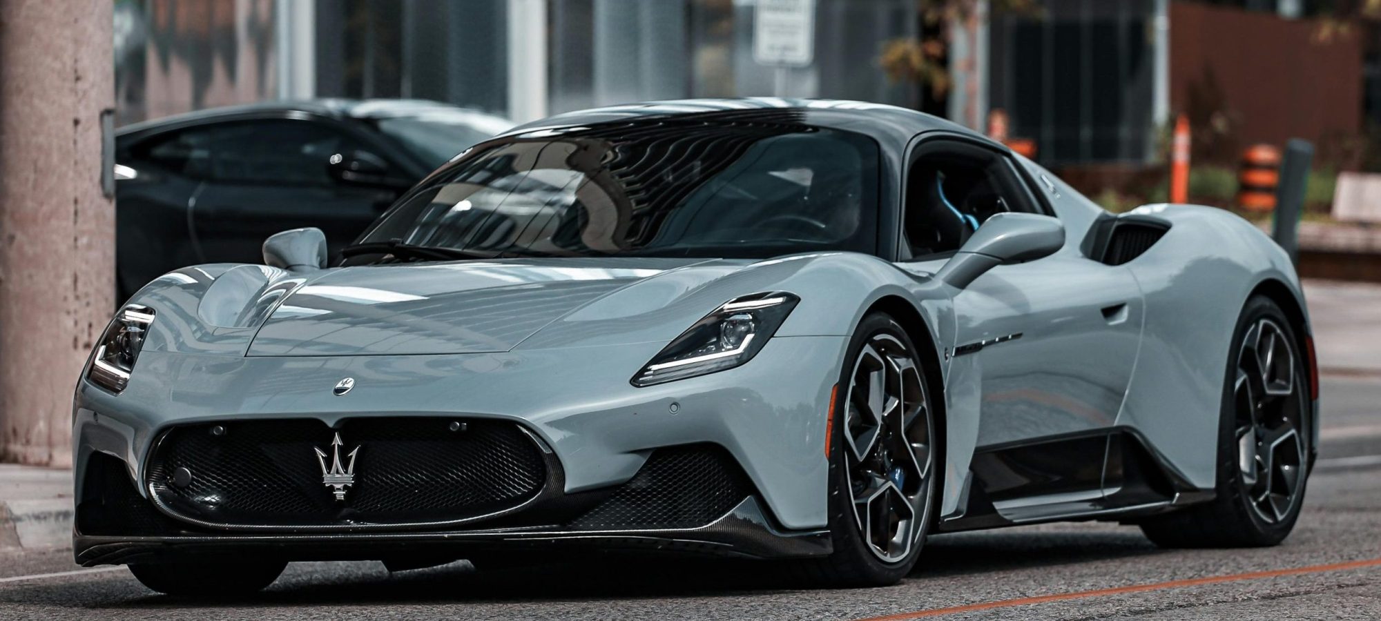Elegant Maserati MC20 supercar parked on an urban street, showcasing modern luxury.