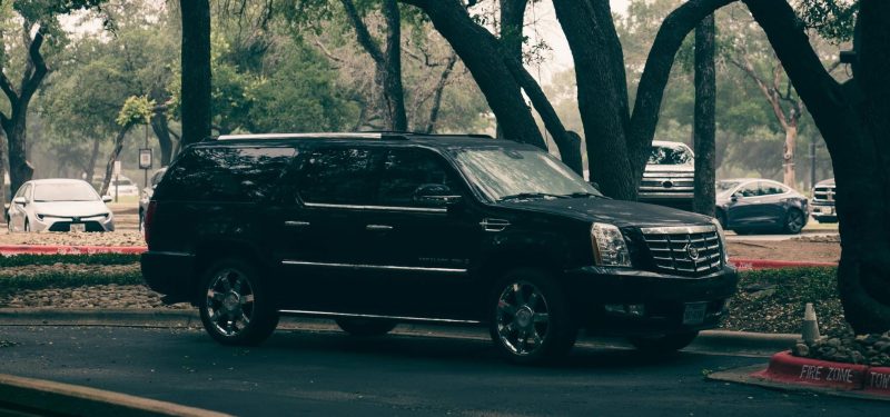 Black Cadillac Escalade Parked Under Trees. Cadillac Escalade spacers