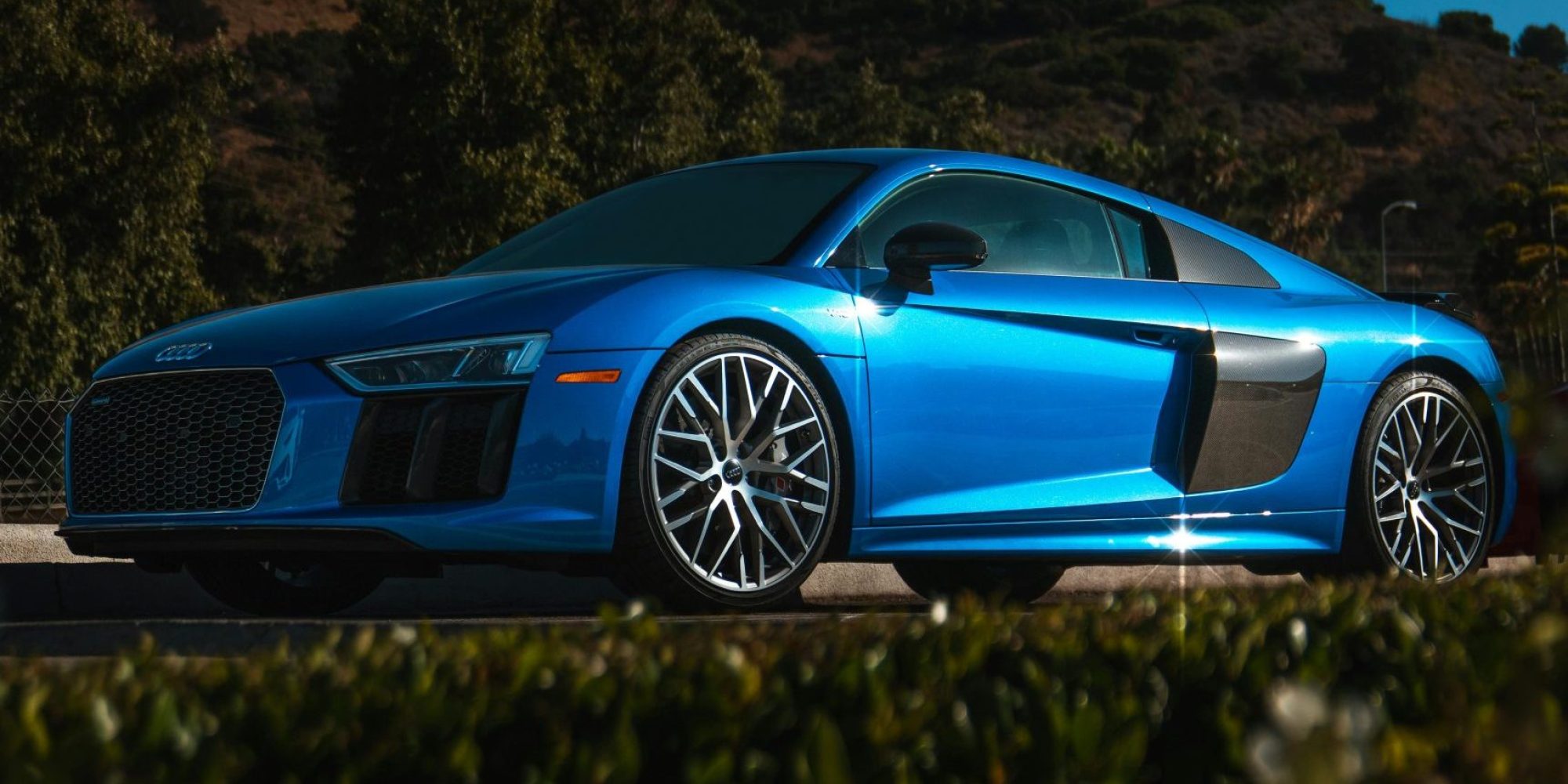 A vibrant blue Audi R8 coupe parked in sunny Calabasas with lush hillside background. | Audi wheel spacers & adapters