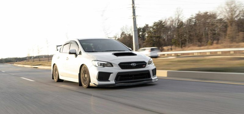 White Subaru WRX in motion on the highway, capturing speed and performance. by Garvin St. Villier via pexels