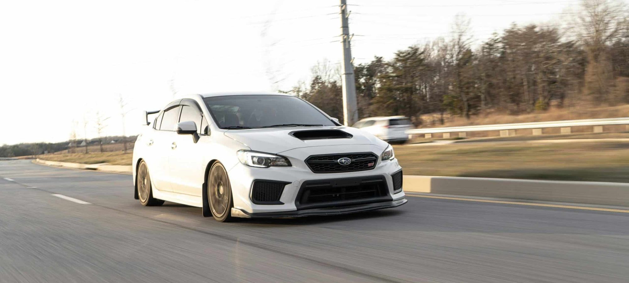 White Subaru WRX in motion on the highway, capturing speed and performance. by Garvin St. Villier via pexels