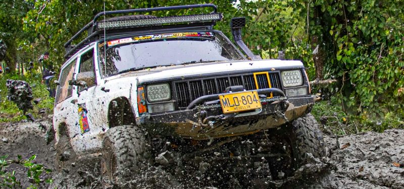 Jeep driving through challenging muddy terrain by Robin Ramos Jeep Grand Cherokee
