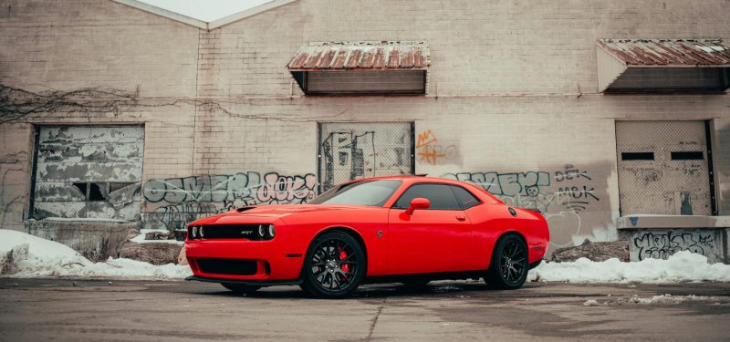 Red Challenger Parked Near Brown Building by Lee Chinyama (Dodge Wheel Spacers)